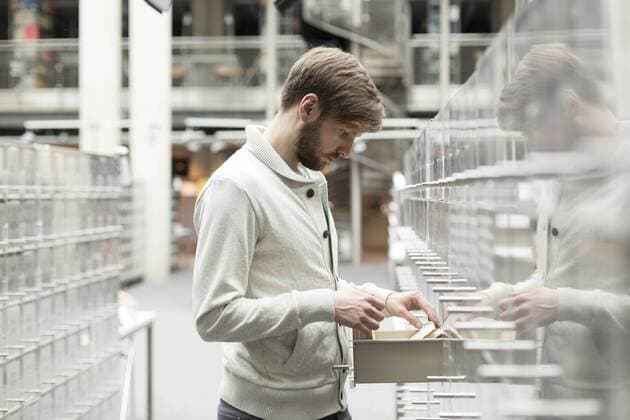 Student in a university library at filing cabinet model released Symbolfoto property released  WESTF019585