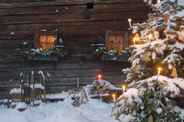 Austria, Salzburg State, Altenmarkt-Zauchensee, facade of wooden cabin with lightened Christmas Tree in the foreground property released  HHF004862