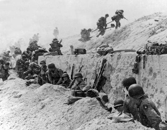 Normandy, France: June 9, 1944. American troops of the 4th Infantry Division at Utah Beach taking a breather before continuing the assault over the hill to the interior of France. 990_16_4-WWII-US-E-DDay_5HR