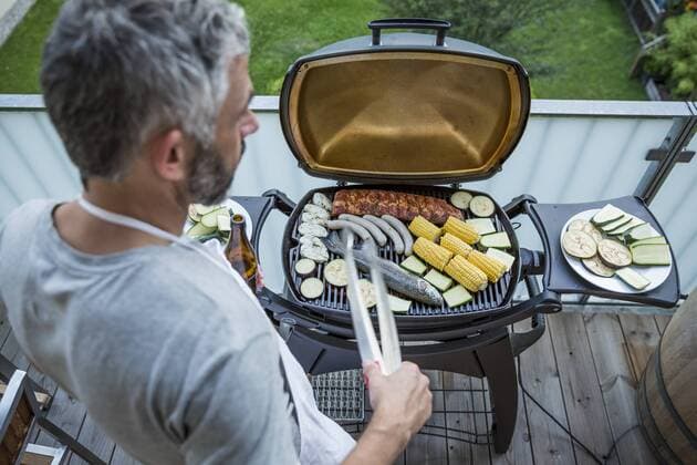Man barbecuing on his balcony model released Symbolfoto property released  MBEF001276