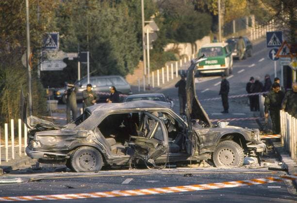 Der Vorstandssprecher der Deutschen Bank, Alfred Herrhausen (59), ist am 30.11.1989 waehrend der Fahrt zur Zentrale der Deutschen Bank in Frankfurt am Main in seinem Auto in Bad Homburg bei einem Sprengstoffanschlag ums Leben gekommen (Foto des zerstoerten Autos wenige Stunden nach dem Anschlag). Um 8.30 Uhr zerreisst eine gewaltige Detonation die gepanzerte Limousine auf dem Seedammweg. Herrhausen verblutet in dem rauchenden Wrack; sein Fahrer Jakob Nix ueberlebt verletzt. Am Tatort findet sich ein DIN-A-5-Blatt mit dem Symbol der linksextremistischen Rote Armee Fraktion (RAF), dem Stern und der Maschinenpistole. Auf dem Zettel stehen nur drei Worte: Kommando Wolfgang Beer . Die Bundesanwaltschaft schreibt die Tat der sogenannten dritten Generation der RAF zu, auch wenn die Beweislage eher duerftig ist. Beer, eine Randfigur der Terrorszene, starb 1980 bei einem Autounfall. (Siehe epd epd EDITORIAL USE ONLY