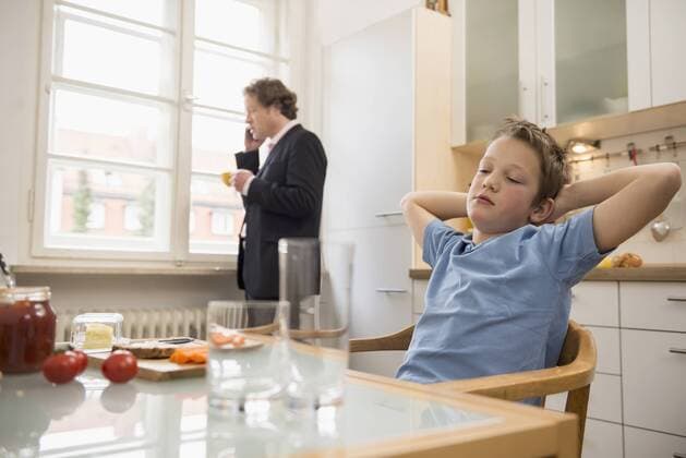 Bored boy in kitchen with father on the phone in background mit_2002_04020