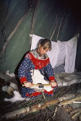Sami woman in lavvu (tent) scraping reindeer hide, Karaskok, Samiland (Lapland), Finnmark, Northern Norway. 1997.  1114970 PetexOxford