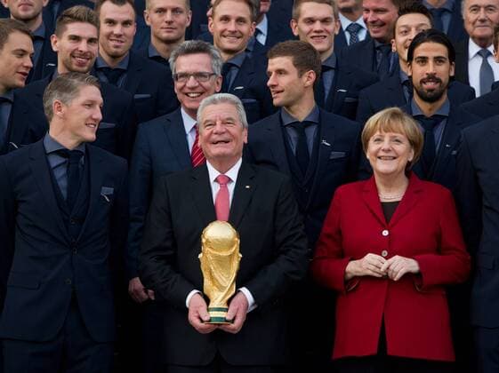 Bastian SCHWEINSTEIGER, Bundespräsident Joachim GAUCK mit dem Weltmeisterpokal, Bundeskanzlerin Angela MERKEL (vordere Reihe, vl), sowie die Nationalmannschaft posieren für ein Gruppenfoto vor dem Schloss Bellevue. Sportlerauszeichnung - Verleihung des Silbernen Lorbeerblattes durch den Bundespräsidenten für die deutsche Fussballnationalmannschaft im Schloss Bellevue in Berlin, Deutschland am 10.11.2014.