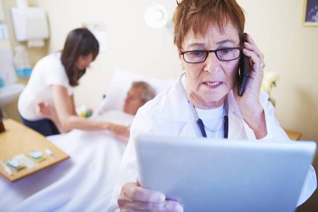 Doctor with cell phone and digital tablet in hospital room model released Symbolfoto property released  ZEF000964