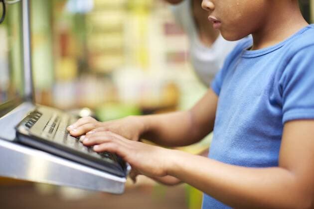 IMAGO Creative: NGO, Ausbildung für Kinder Young woman and boy using computer in library model released Symbolfoto property released  ZEF000207