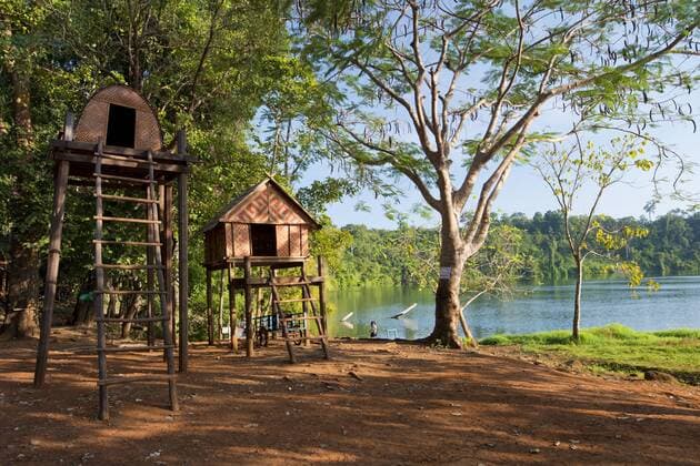 Pfahlhäuser, auf hohen Stelzen gebautes Junggesellenhaus des Volkes der Kroeung am Ufer des Vulkansees Yak Loam, Yeak Laom, Beung Yeak Loam, Banlung, Provinz Ratanakiri, Kambodscha, Asien iblolf03854153.jpg