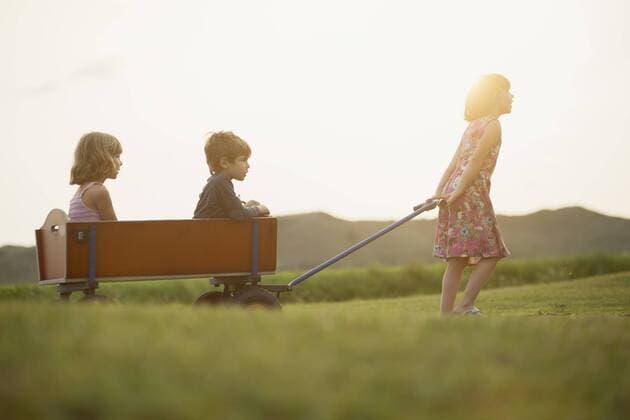 Girl pulling trolley with little boy and girl sitting inside model released Symbolfoto  MVC000134