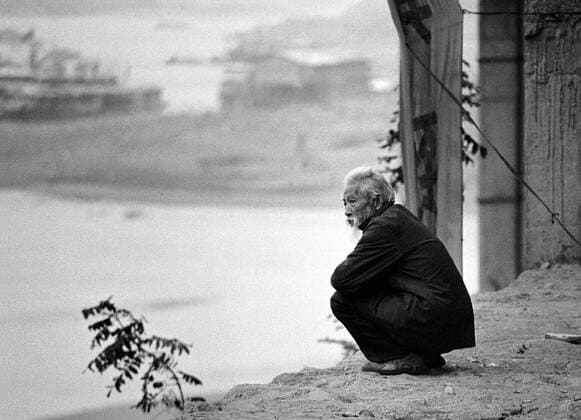 Am Yangtze-Fluss China Am Yangtze-Fluss in der Provinz Hubei China Die chinesische Regierung plant in der Provinz Hubei den Yangtze-Fluss mit einem Staudamm zur Stromgewinnung aufzustauen. Dabei werden ca. 3 Millionen Menschen umgesiedelt. Hier: Ein alter Mann blickt auf dem Flauss. Sein Ort Zigui wird vom Staudamm ueberspuelt werden und mehrere tausend Menschen verlieren ihre Heimat. 1992, Zigui, Provinz Hubei China