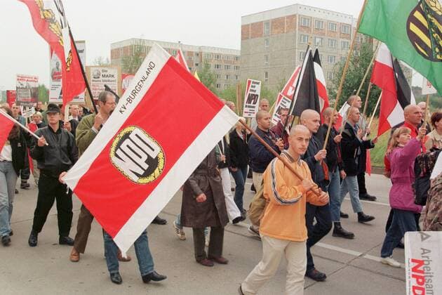 Mecklenburg-Vorpommern Rostock Politik Neonazis NPD-Aufmarsch Vor allem mit Westkadern fuerte die rechtsextremistische NPD in Mecklenburg-Vorpommern einen sogenannten Schwerpunktwahlkampf zur Landtagswahlt 1998. Die Parteifuehrung rechnete sich in Mecklenburg-Vorpommern beste Chancen fuer Landtagsmandate aus. Sie blieb jedoch unter der Fuenf-Prozent-Huerde. Hier: Teilnehmer mit Fahne des NPD-Kreisverbandes Burgenland bei der NPD-Demonstration zum Wahlkampfabschluss im Rostocker Stadtteil Dierkow. 19.9.1998, Rostock
