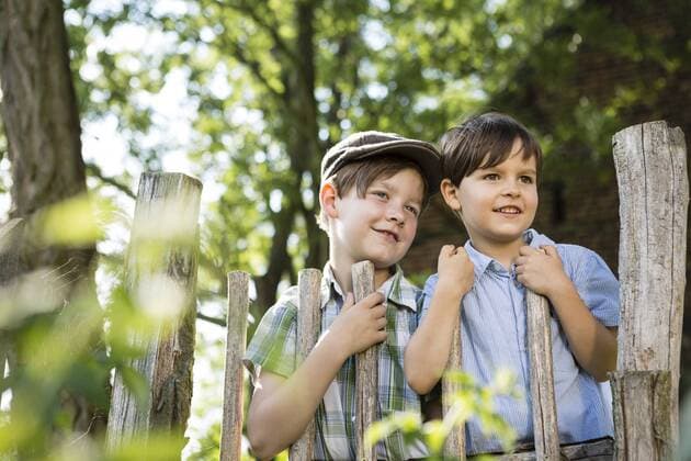 Portrait of two little boys standing behind a wooden fence model released Symbolfoto  FKIF000042