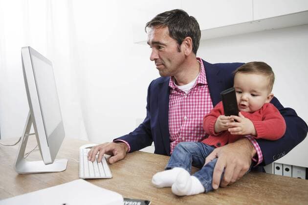 Businessman with baby boy working from home model released Symbolfoto  GDF000616
