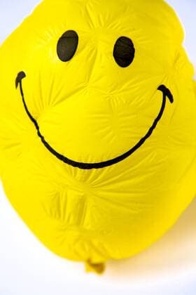 Alter Luftballon, gelb, mit freundlichem Smiley Gesicht, mit der Zeit geschrumpelt und eingefallen, faltig