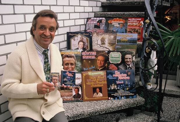 Der Sänger Günter Wewel sitzt auf der Treppe neben seinen vielen Schallplatten im Jahre 1992.