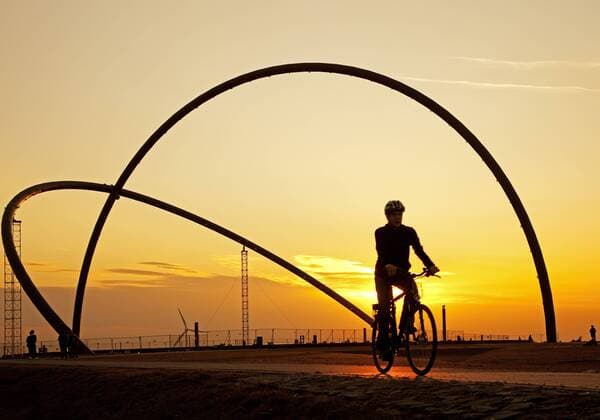 Fahrradfahrer vor dem Horizontobservatorium auf der Halde Hoheward in Herten bei untergehender Sonne, Deutschland, Nordrhein-Westfalen, Ruhrgebiet, Herten biker at Horizontobservatorium on stockpile Hoheward in Herten at sunset, Germany, North Rhine-Westphalia, Ruhr Area, Herten BLWS291547