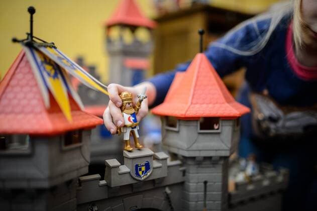 IMAGO Creative: Jahreszeit Winter, Fantasievoll drinnen spielen Ein Mädchen spielt mit ihrer Playmobil Ritterburg.