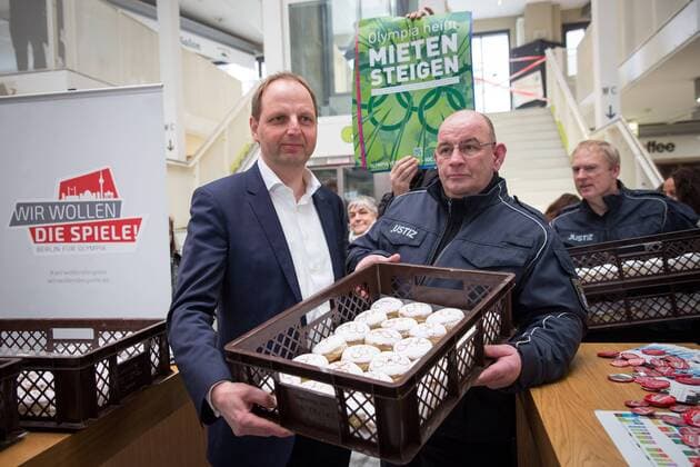 Olympia-Pfannkuchen Thomas Heilmann (CDU), Berliner Senator für Justiz und Verbraucherschutz verteillt in der Kreuzberger Marheineke-Markthalle Pfannkuchen mit dem Olympia-Logo. Mit den von Häftlingen gebackenen Pfannkuchen will der Senator für Olympia in Berlin zu werben. Ca. 15 Olympiagegner protestieren mit Sprechchören und Plakaten gegen eine Olympiabewerbung Berlins.