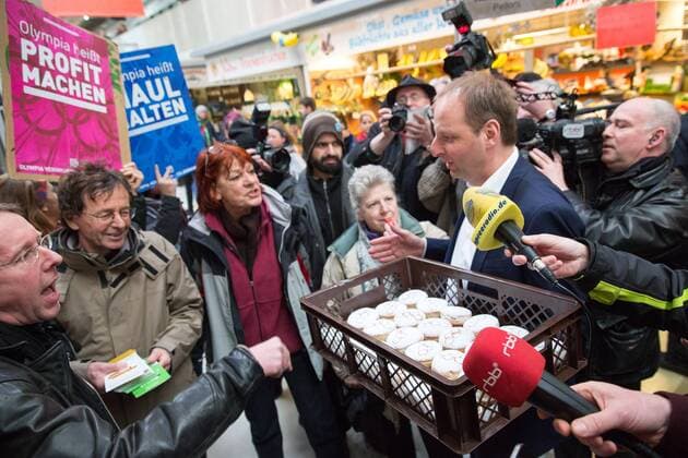 Olympia-Pfannkuchen Thomas Heilmann (CDU), Berliner Senator für Justiz und Verbraucherschutz verteillt in der Kreuzberger Marheineke-Markthalle Pfannkuchen mit dem Olympia-Logo. Mit den von Häftlingen gebackenen Pfannkuchen will der Senator für Olympia in Berlin zu werben. Ca. 15 Olympiagegner protestieren mit Sprechchören und Plakaten gegen eine Olympiabewerbung Berlins.