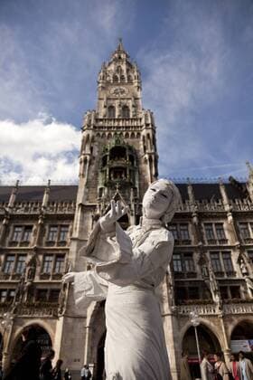 IMAGO Creative: Stadt-Dichotomien Germany, Bavaria, Munich, street artist on Marienplatz in front of new town hall  PC000048