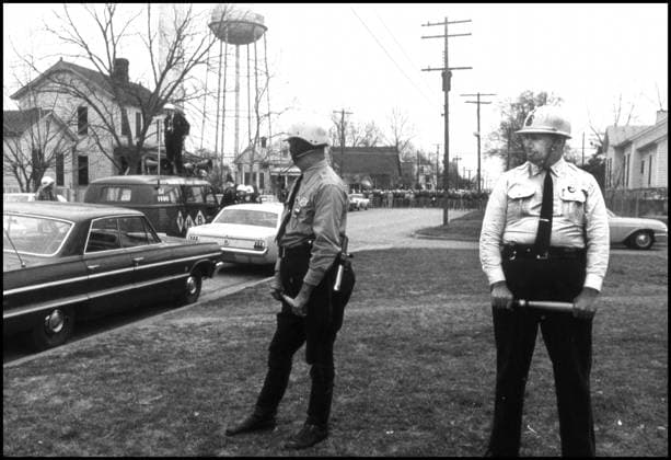 IMAGO History, U.S. Bürgerrechtsbewegung: 1954-1968 Mar 6, 1965 - Selma, Alabama, U.S. - Police and news photographers wait with marchers outside during demonstrations while Dr. Martin Luther King, Jr. holds a meeting with other leaders of the Civil Rights Movement, prior to the next day s successful march to Montgomery. The three Selma to Montgomery marches in 1965 were part of the Selma Voting Rights Movement and led to the passage that year of the Voting Rights Act, a landmark federal achievement of the 1960s American Civil Rights Movement. Sunday March 7, 1965 Alabama whites, calling themselves the Concerned White Citizens of Alabama, arrive in Selma to march in support of black rights. Klan members have followed them into town to protest their march, and the demonstration breaks up as it is clear violence is about to break out, seventeen marchers were hospitalized and leaving civil rights activists J. Lee Jackson and J. Reeb dead. - ZUMAw130