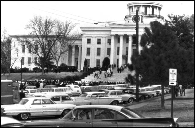 IMAGO History, U.S. Bürgerrechtsbewegung: 1954-1968 Mar 6, 1965 - Selma, Alabama, U.S. - Police and news photographers wait with marchers outside during demonstrations while Dr. Martin Luther King, Jr. holds a meeting with other leaders of the Civil Rights Movement, prior to the next day s successful march to Montgomery. The three Selma to Montgomery marches in 1965 were part of the Selma Voting Rights Movement and led to the passage that year of the Voting Rights Act, a landmark federal achievement of the 1960s American Civil Rights Movement. Sunday March 7, 1965 Alabama whites, calling themselves the Concerned White Citizens of Alabama, arrive in Selma to march in support of black rights. Klan members have followed them into town to protest their march, and the demonstration breaks up as it is clear violence is about to break out, seventeen marchers were hospitalized and leaving civil rights activists J. Lee Jackson and J. Reeb dead. - ZUMAw130