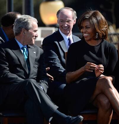 First Lady Michelle Obama (R) smiles with President George W. Bush during a visit to the historic Edmund Pettus Bridge where President Barack Obama and Rep. John Lewis, D-Ga., spoke about the violence 50 years ago during the March on Selma, in Selma, Alabama, March 7, 2015.  AJP2015030723 DAVIDxTULIS