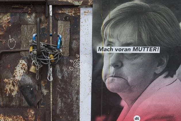 Ein Plakat mit der Bundeskanzlerin Merkel an einer mit Ketten gesicherten Tür am ehemaligen Bahnpostamt in der Mühlenstraße am Ostbahnhof in Berlin-Friedrichshain. Mach voran Mutter