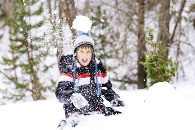 Happy boy throwing a snowball in the woods model released Symbolfoto  GEMF000088