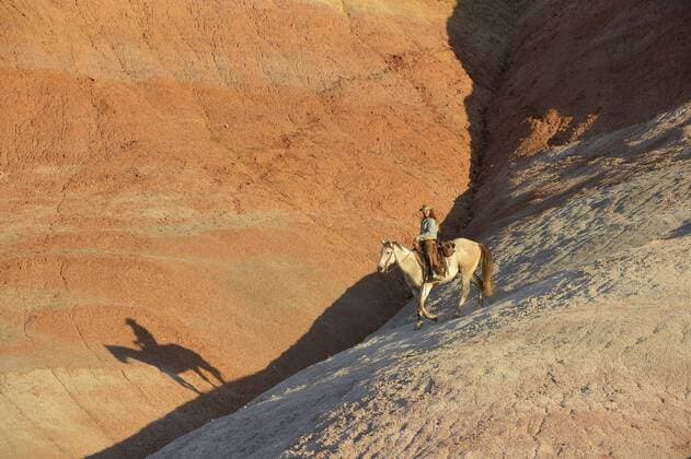 USA, Wyoming, cowgirl riding in badlands at twilight model released Symbolfoto property released  RUEF001442