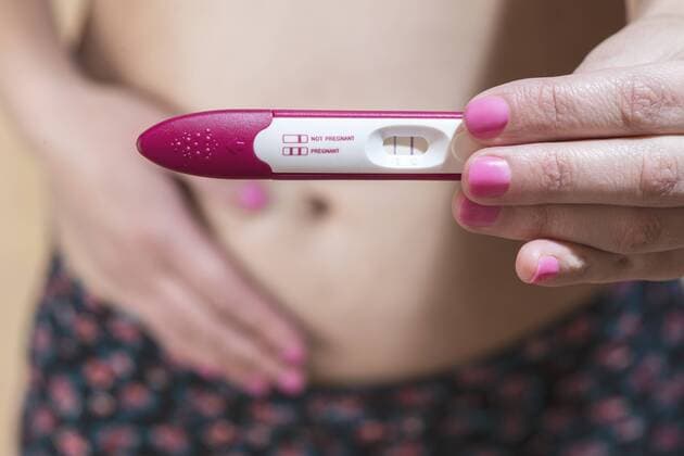 Woman holding a pregnancy test model released Symbolfoto  DEGF000356