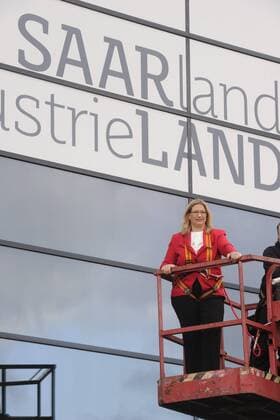 Saarlands Wirtschaftsministerin Anke Rehlinger (SPD) wirbt an der Fassade des Saarbrücker Wirtschaftsministeriums mit einem Schriftzug Saarland Industrieland am Freitag (27.3.2014) und hilft selbst dabei, die Elemente mit einem Hubsteiger zu befestigen.