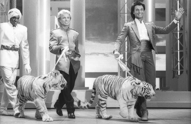 Siegfried (Mi.) und Roy (Tierbändiger, Magier) 06 87 ru Siegfried (Mitte) und Roy (re.) im Juni 1987 in Mensch Meier, ARD Deutsche Amerikaner Deutschamerikaner Deutschland USA Mann Männer TV Fernsehen Show Magie Zauberei Magier Zauberer Entertainment Las Vegas Tiger weiße Dompteure Dompteur Roy Uwe Ludwig Horn Siegfried Fischbacher german american show stars quer ganz gehend gestikulierend lächelnd lachend sprechend sw