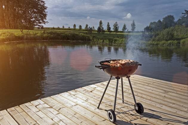 Estonia, barbecue grill on wooden platform by lake property released  JAAF000194