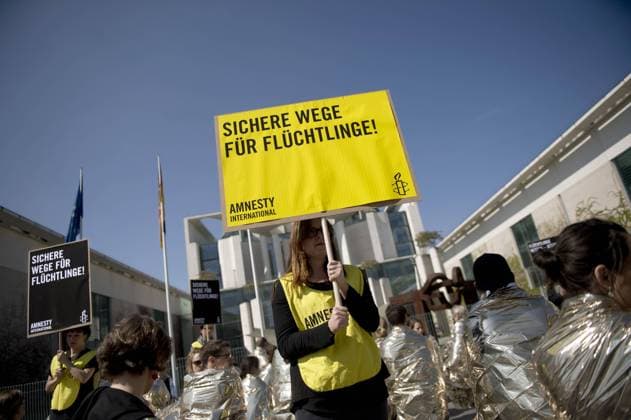 Mahnwache Massensterben im Mittelmeer stoppen - Amnesty International DEU, Deutschland, Germany, Berlin, 23.04.2015 Plakate Massensterben im Mittelmeer stoppen sofort und Fluechtlinge retten sofort bei der Aktion und Mahnwache von Amnesty International vor dem Bundeskanzleramt in Berlin. Der Protest richtet sich gegen die aktuelle Fluechtlingspolitik der Bundesregierung und fuer sichere und legale Fluchtwege und Seenotrettung. Die gescheiterte Politik der Abschottung fordert Woche für Woche neue Todesopfer im Mittelmeer - mehr als 1 100 Fluechtlinge allein in der vergangenen Woche. Amnesty International activists holding a poster Massensterben im Mittelmeer stoppen sofort, Europe borders kill, in protest against German government s refugee policy in front of the chancellery office in Berlin