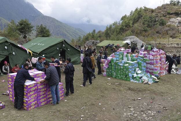 (150426) -- XIGAZE, April 26, 2015 -- Rescuers distribute relief goods to villagers in Gyirong County in Xigaze, southwest China s Tibet Autonomous Region, April 26, 2015. The death toll in Tibet has climbed to 17 and the number of the injured stood at 53, after an 8.1-magnitude earthquake struck neighboring Nepal on Saturday, local authorities said Sunday. ) (yxb) CHINA-TIBET-NEPAL EARTHQUAKE (CN) LiuxDongjun 