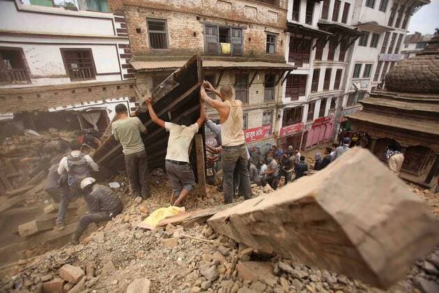Locals help rescue after a massive earthquake aftermath, in Kathmandu, Nepal, April 25, 2015. New tremors sent shocked survivors scurrying outdoors just 24 hours after a devastating 7.9 magnitude earthquake shook the region which so far has taken the lives of at least 2,500 people.  NEP2015042605 SanjogxManandhar