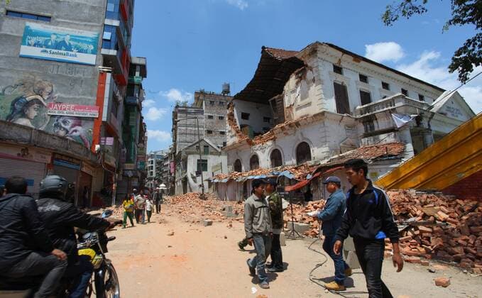 People pass by a damaged school after a massive earthquake at Bhotahity in Kathmandu, Nepal, April 27, 2015. A total of 3,218 people had been killed and about 6,500 others injured in the powerful earthquake that struck Nepal at midday Saturday, the authorities said Monday morning. ) NEPAL-KATHMANDU-EARTHQUAKE-AFTERMATH SunilxSharma 