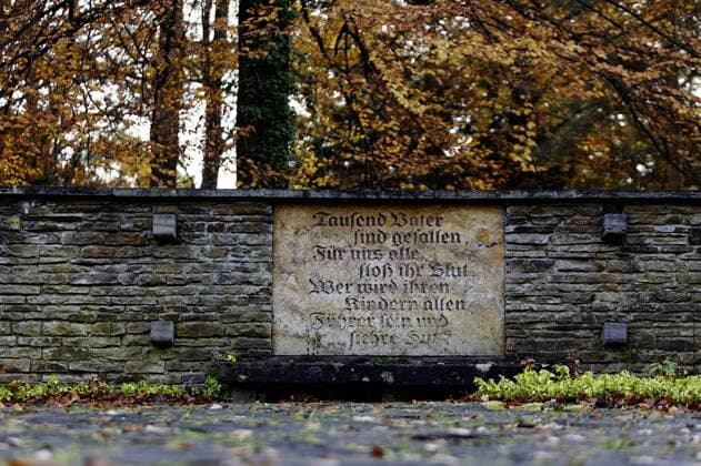 DEU, Deutschland, Stuttgart, 24.10.2014 - Waldfriedhof in Stuttgart. Kriegsgraeber. Steinplatte mit der Inschrift: Tausend Vaeter sind gefallen, Fuer uns alle floss ihr Blut. Wer wird ihren Kindern allen Fuehrer sein und sichre Hut? Â