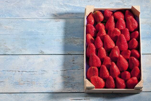 Fresh strawberries in wooden box on blue wood  CSF025334