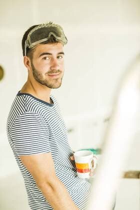 Young man having a coffee break from renovating model released Symbolfoto  UUF004167