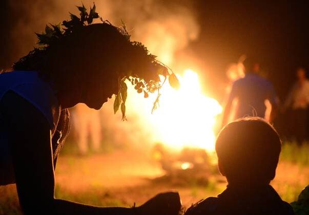 VLADIVOSTOK, RUSSIA. JUNE 20, 2015. A girl wearing a floral wreath stands by a bonfire during festivities marking Ivan Kupala Day, a pagan summer solstice celebration, on Russky Island. Yuri Smityuk TASS  TS006547