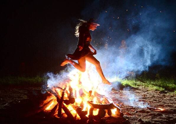 VLADIVOSTOK, RUSSIA. JUNE 20, 2015. A girl jumps over a bonfire during festivities marking Ivan Kupala Day, a pagan summer solstice celebration, on Russky Island. Yuri Smityuk TASS  TS0067E8
