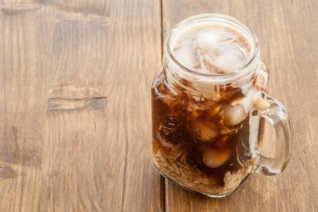 Eiskaffee in vintage Glas Krug auf rustikalem dunklem Holz  1079702312