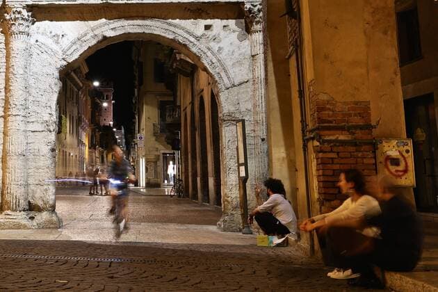 Italien, Verona A woman rides under the Borsari Gate in Verona July 27, 2015. Verona is a city in north Italy s Veneto. As one of the main tourist destinations in north Italy, the city has artistic heritages, annual fairs, shows, and operas. It was listed as a UNESCO world heritage site in 2000 for its historical buildings. ) ITALY-VERONA-DAILY LIFE JinxYu 