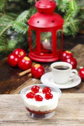 Delightful tiramisu dessert decorated with cherries. Christmas setting, cup of coffee and red lantern in the background. Italian xmas.  Copyright: KantarukxAgnieszka bew1825171