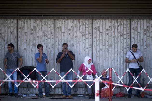 Zentrale Aufnahmeeinrichtung fuer Asylbewerber Berlin DEU, Deutschland, Germany, Berlin, 03.08.2015 Asylsuchende warten vor der Zentralen Aufnahmeeinrichtung des Landes Berlin fuer Asylbewerber, ZAA, in Berlin Tiergarten. Die Einrichtung vom Landesamt fuer Gesundheit und Soziales Lageso ist fuer Asylbewerber erst Anlaufstation und aufgrund der gestiegenen Bewerber enorm ueberfuellt. Nach Angaben des BAMF kamen von den insgesamt rund 190.000 Asylantraegen in Deutschland seit Anfang des Jahres rund 78.000 aus Staaten des Westbalkan. Nur ein Bruchteil der Antraege aber wird bewilligt - darum will die Bundesregierung ihre Asylverfahren moeglichst schnell durchziehen und die abgelehnten Bewerber zurueckschicken. Asyl seekers waiting outside of the Zentrale Aufnahmeeinrichtung of the State Office of Health and Social Affairs Lageso in Moabit Berlin. Here immigrants, refugees and asylum seekers
