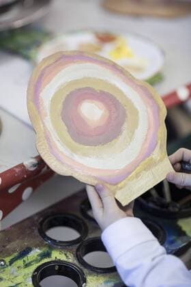IMAGO Creative: NGO, Ausbildung für Kinder Smiling girl showing her painting in art class at school model released Symbolfoto property released  ZEF006131