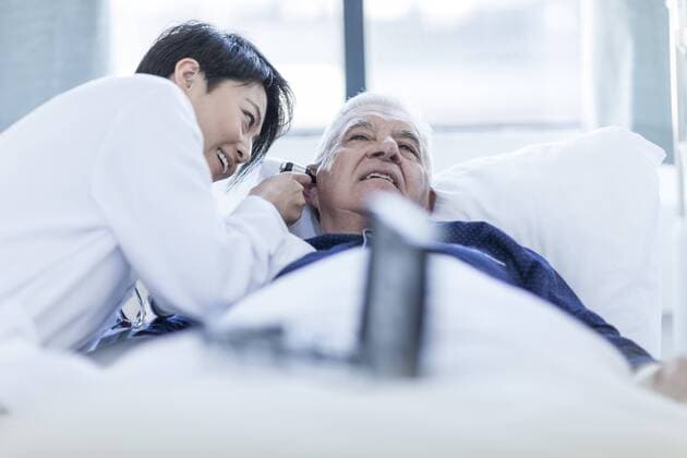 Doctor examining patient with otoscope in a hospital model released Symbolfoto property released  ZEF006263