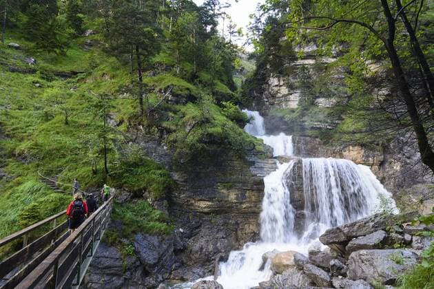 Kuhfluchtwasserfälle im Kuhfluchtsgraben mit Wanderern in Farchant, Oberbayern, Estergebirge, Bayern, Deutschland model released