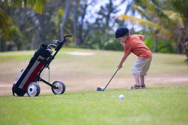 kleiner Junge spielt Golf auf einem Golfplatz 4 years old boy playing golf on a golf course BLWS234329